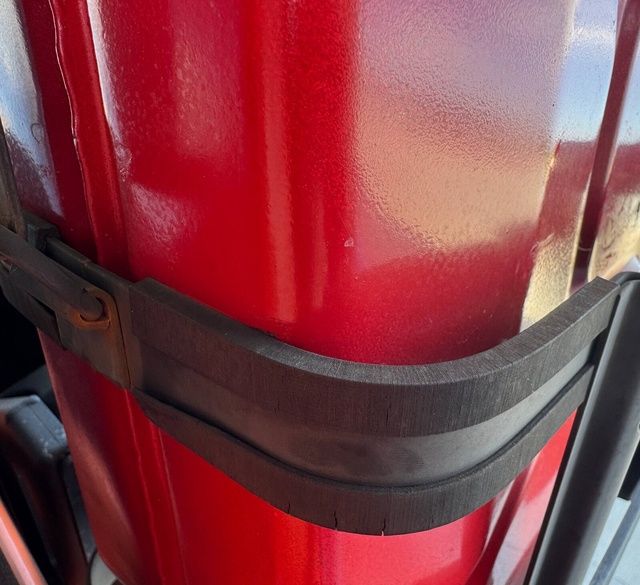 Black flexible 3D-printed bumpers wrapped around the metal straps of a cage holding a red jerry can